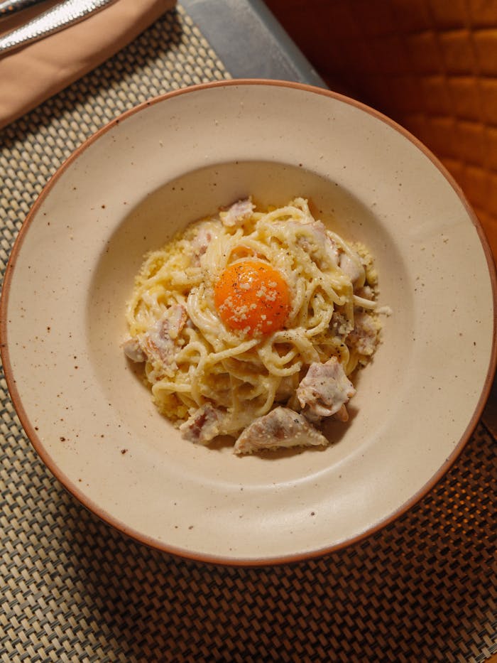 Delicious carbonara served with creamy pasta and a fresh egg yolk topping.